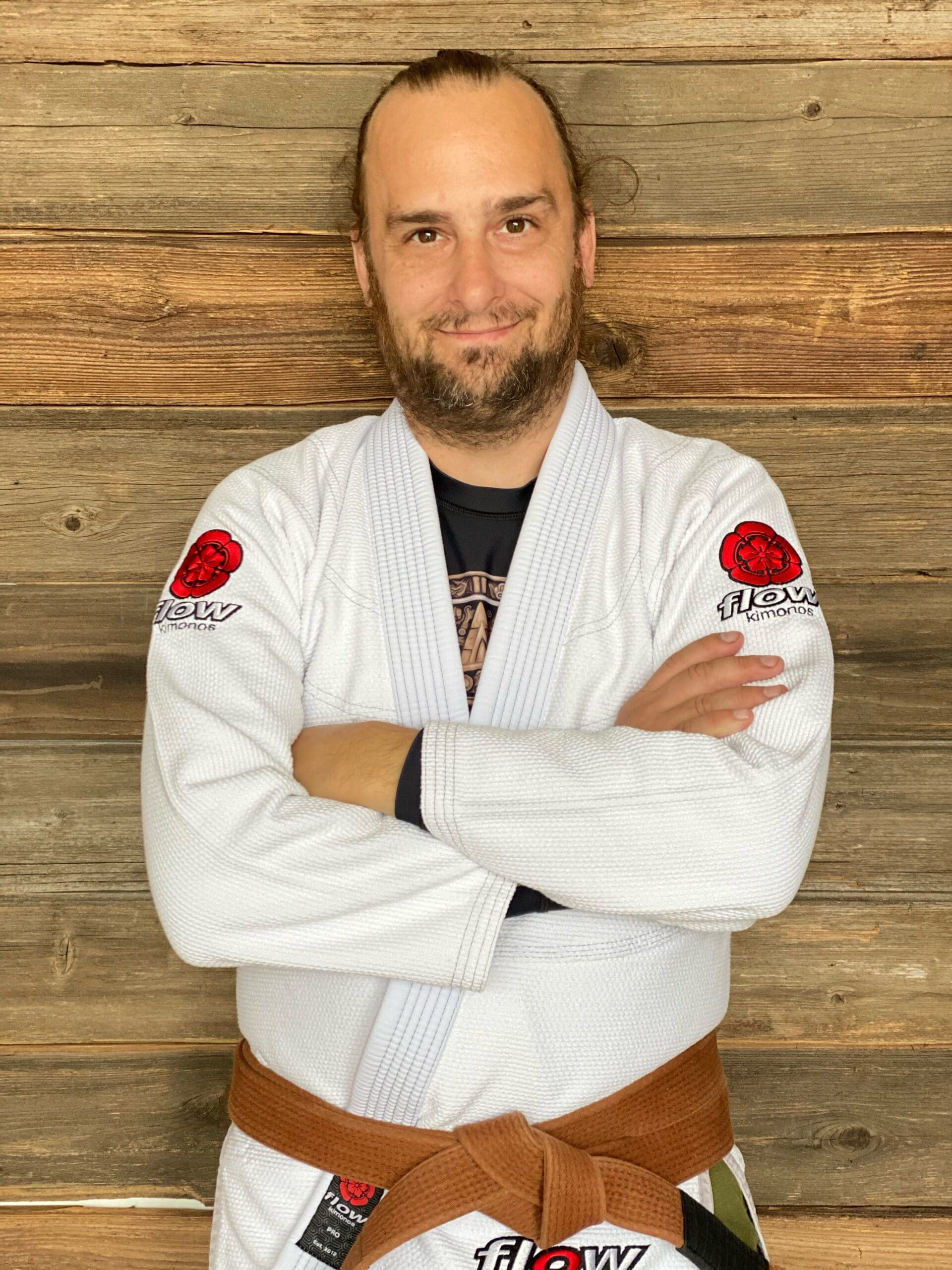 Coach Shane posing for a picture in a white Jiu-Jitsu gi with his brown belt on in Blaine MN